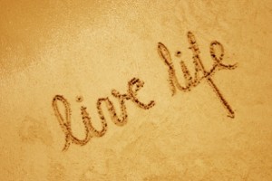 bigstock-Live-life-handwritten-in-sand--19587326